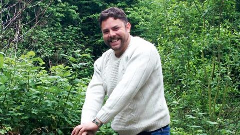 Man smiling in white jumper