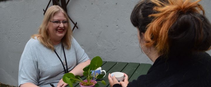 Woman smiling outside talking with someone